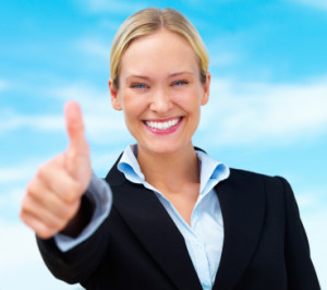 Beautiful happy blond business woman showing thumbs up