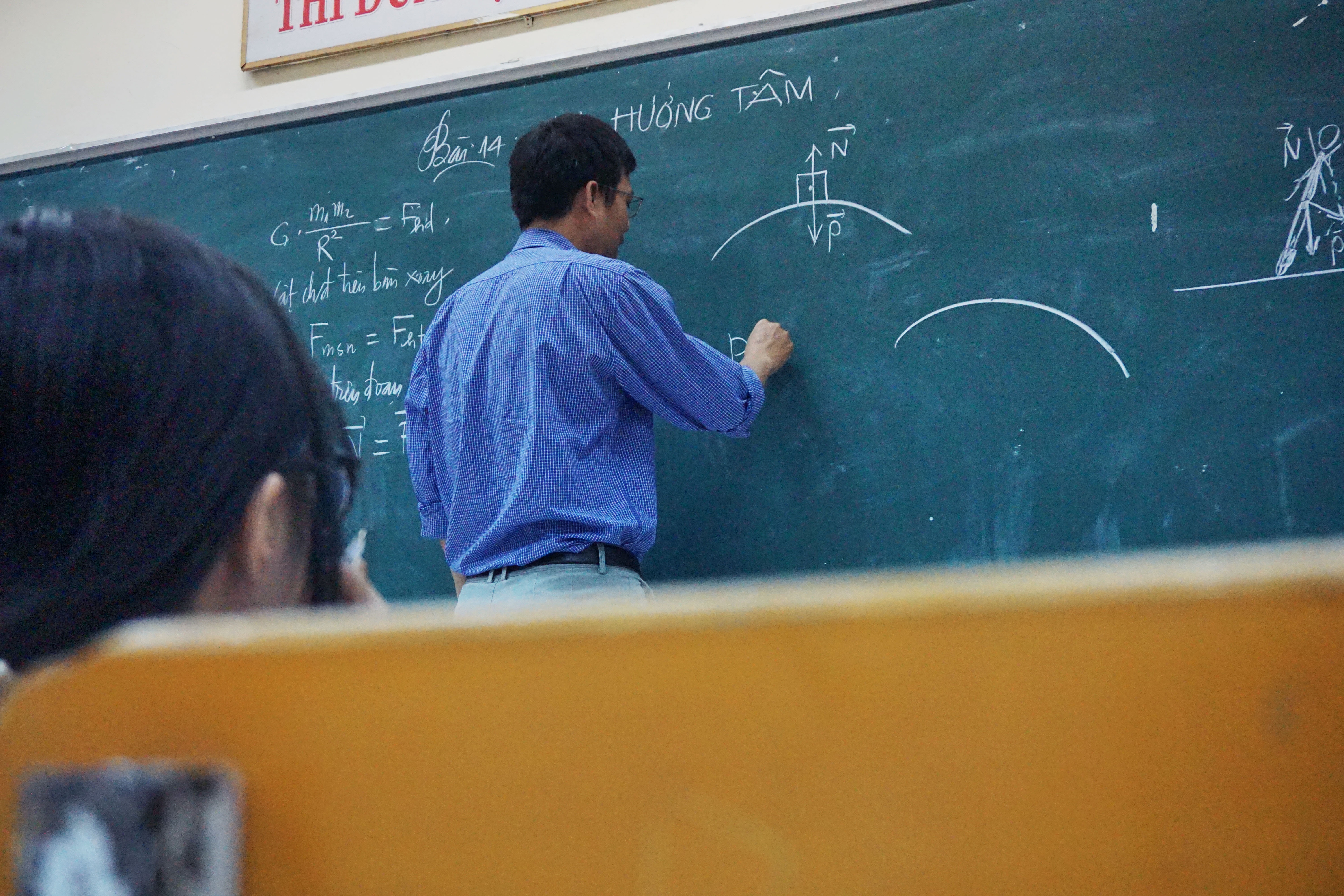 Professor writing on chalkboard